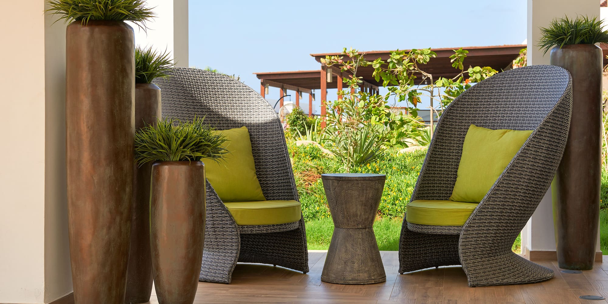 a patio with chairs and plants