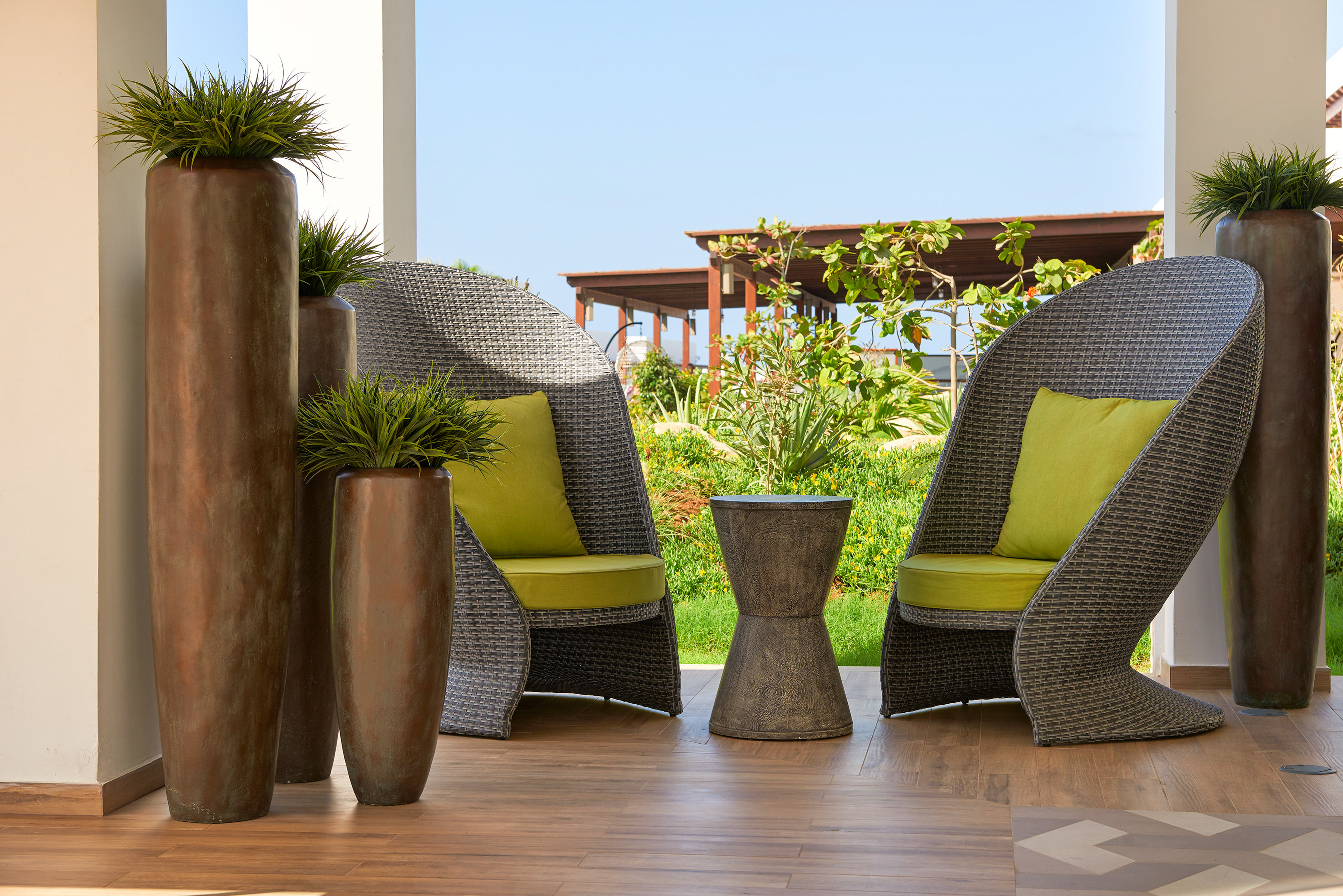 a patio with chairs and plants