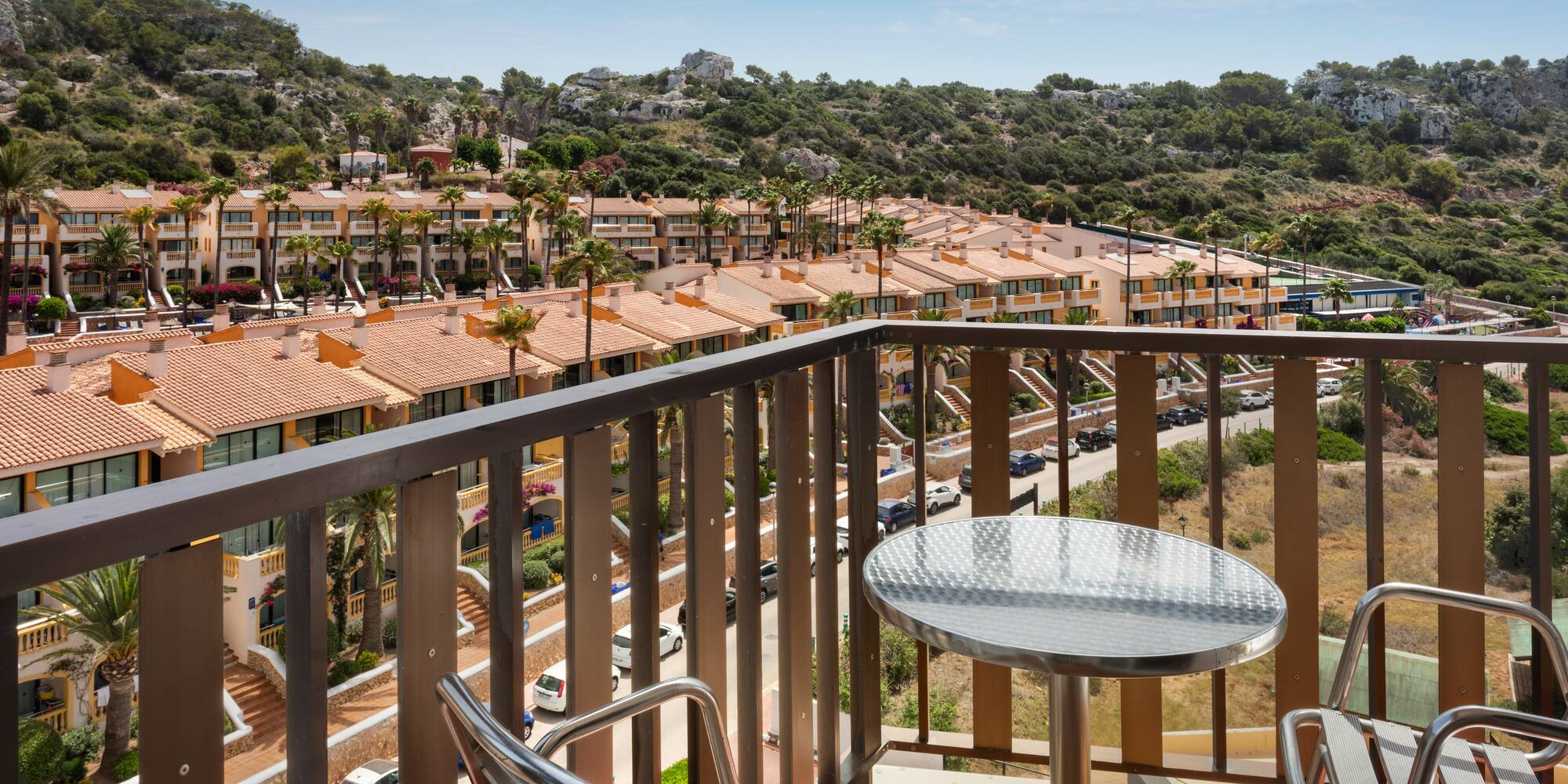 a balcony with a table and chairs and a view of a town
