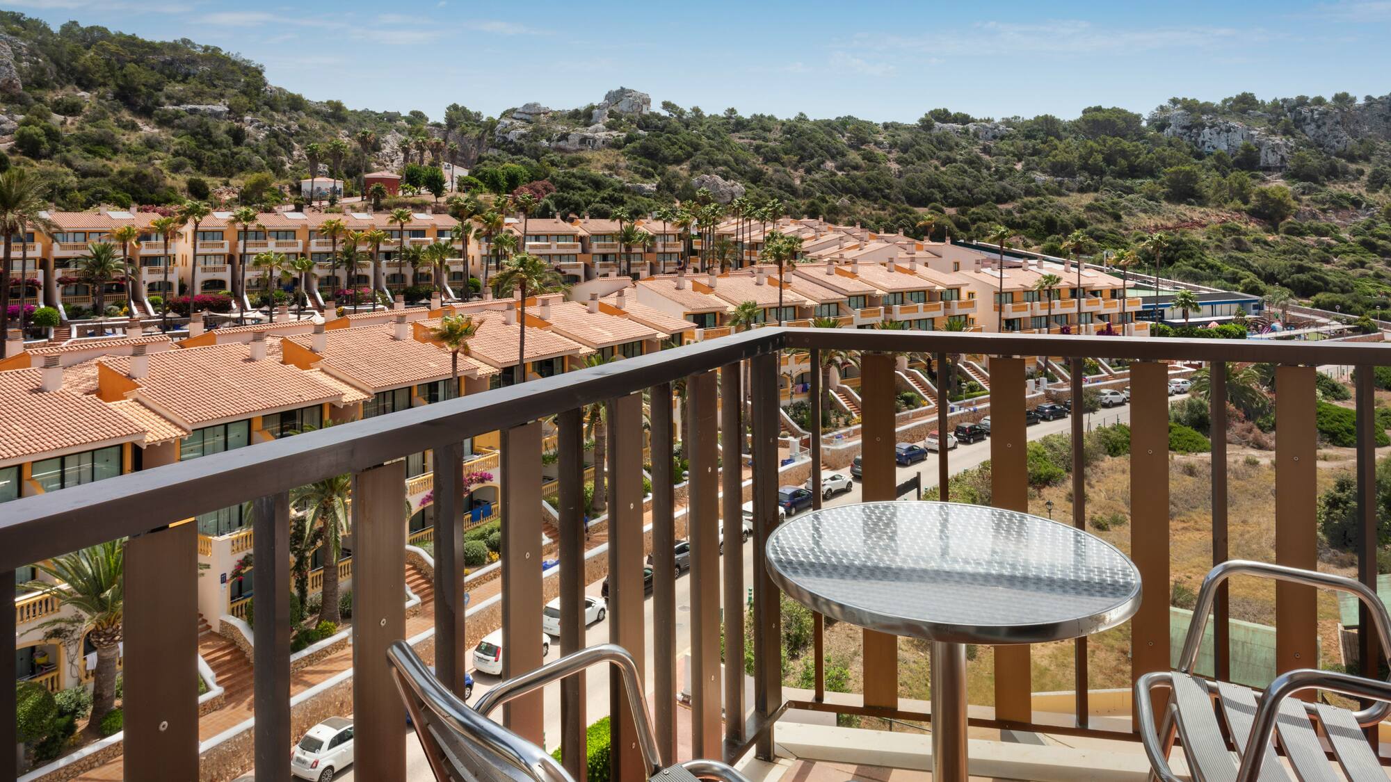 a balcony with a table and chairs and a view of a town