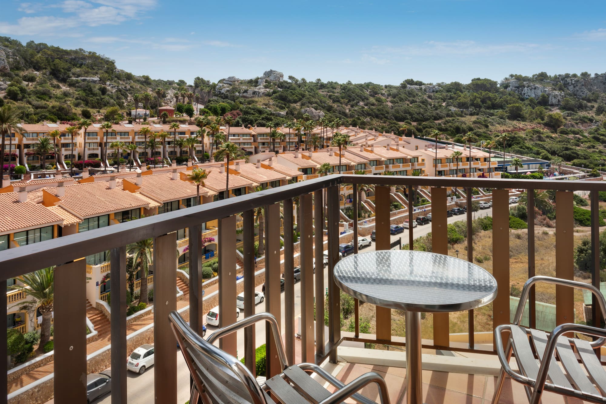 a balcony with a table and chairs and a view of a town