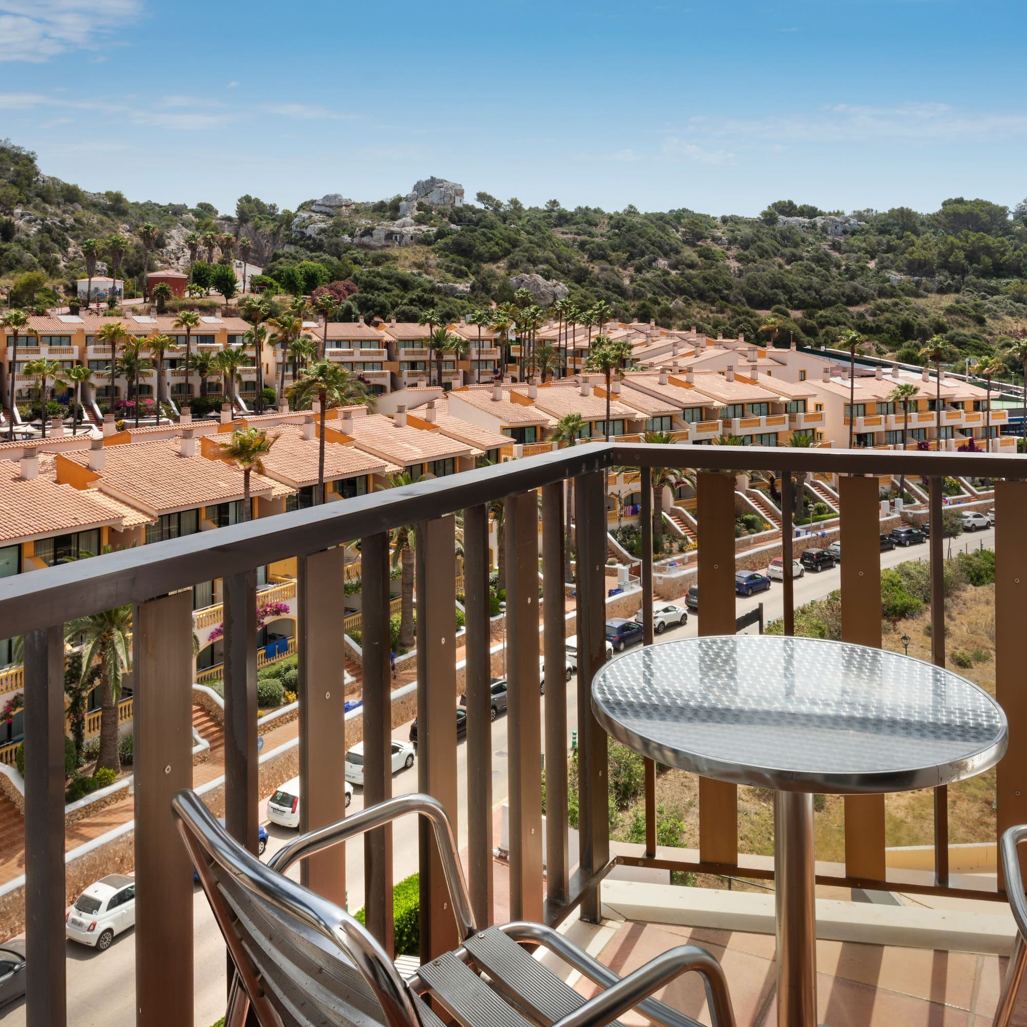 a balcony with a table and chairs and a view of a town