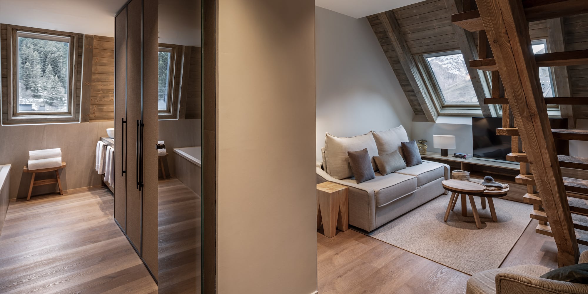 Modern chalet apartment living area with mountain view, wood interior, and bath.