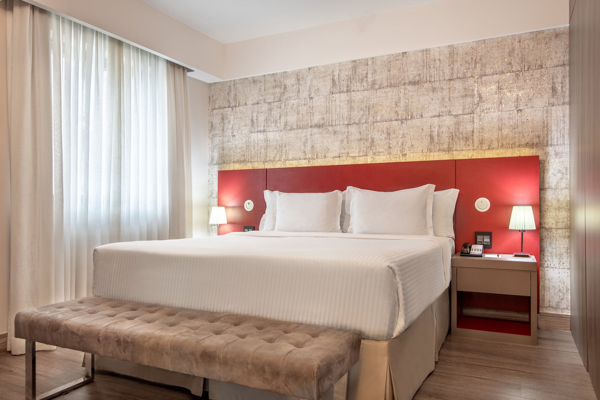 a bed with a bench and a lamp