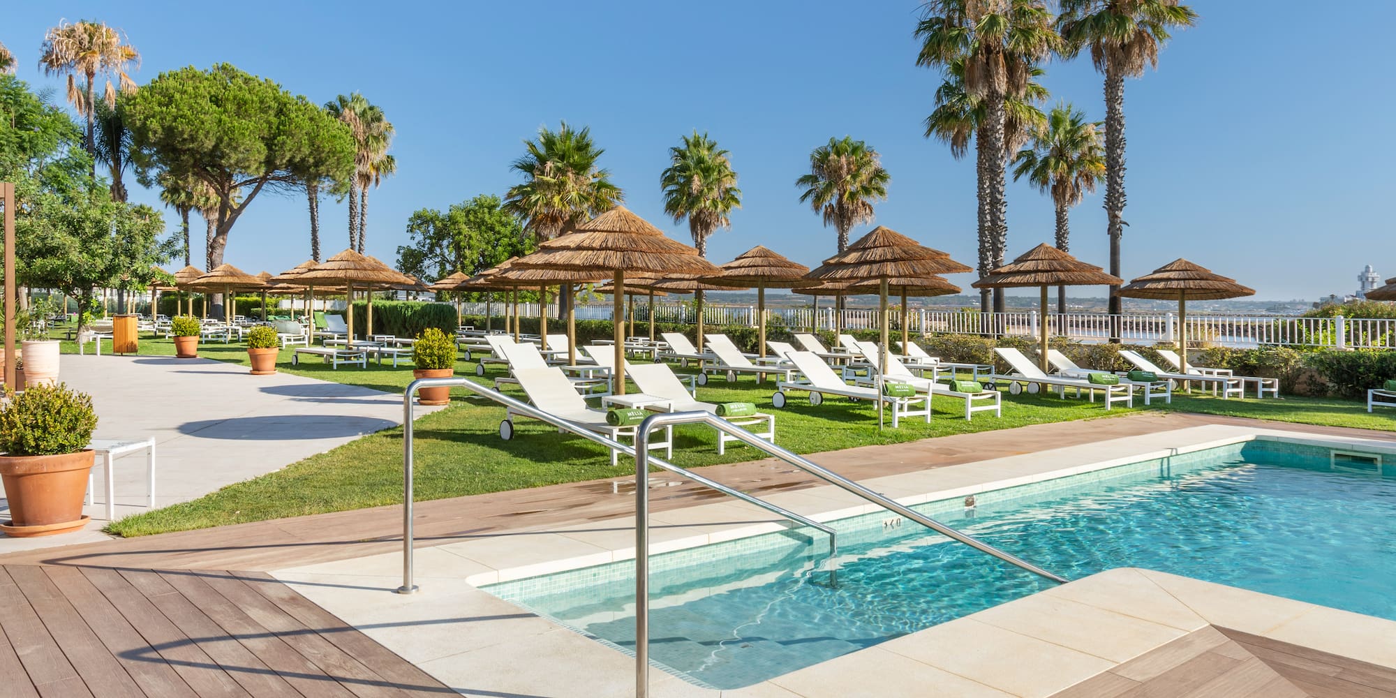 a pool with lounge chairs and umbrellas