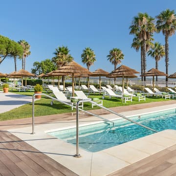 a pool with lounge chairs and umbrellas