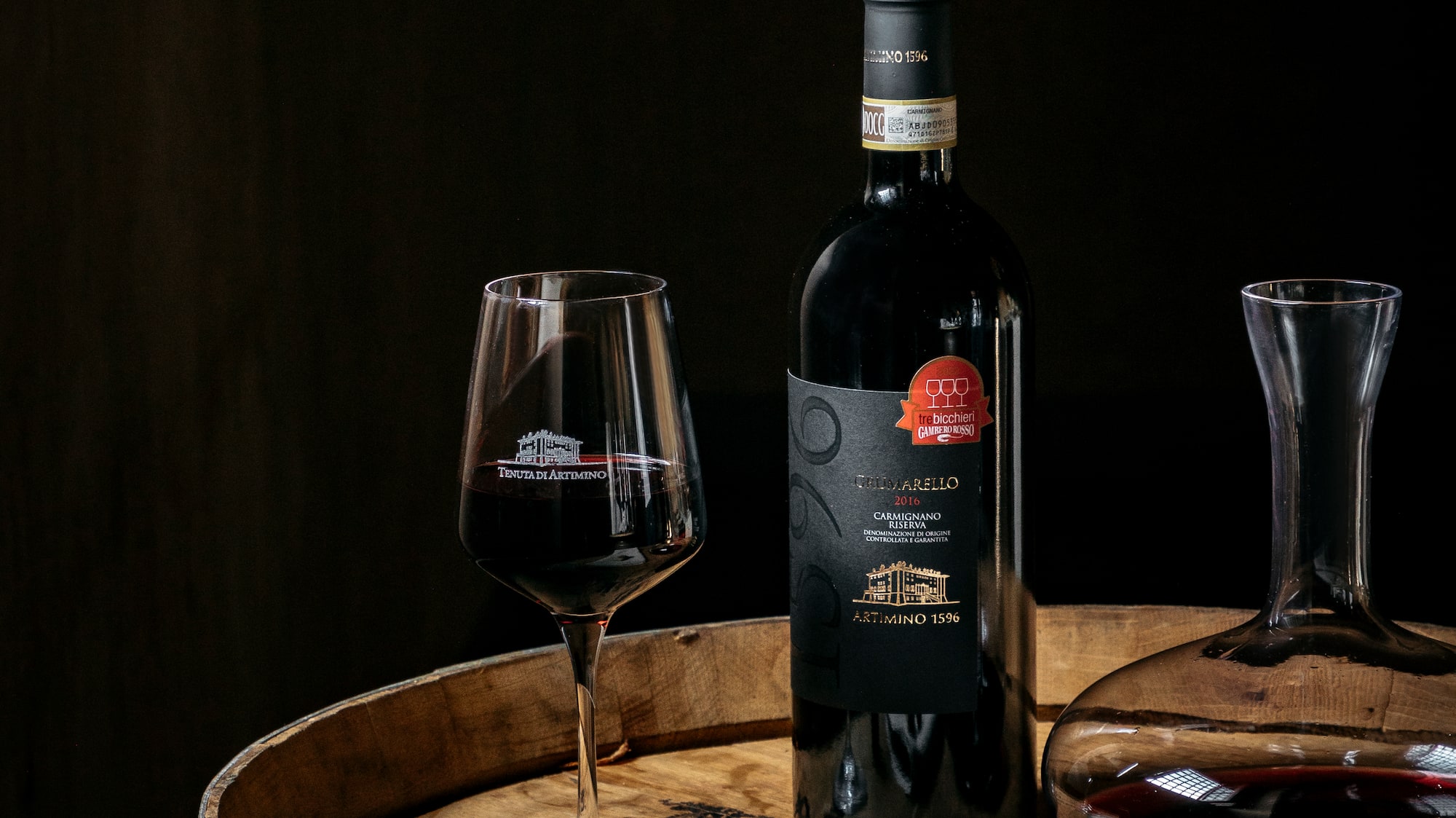 a bottle of wine and a glass of wine on a barrel