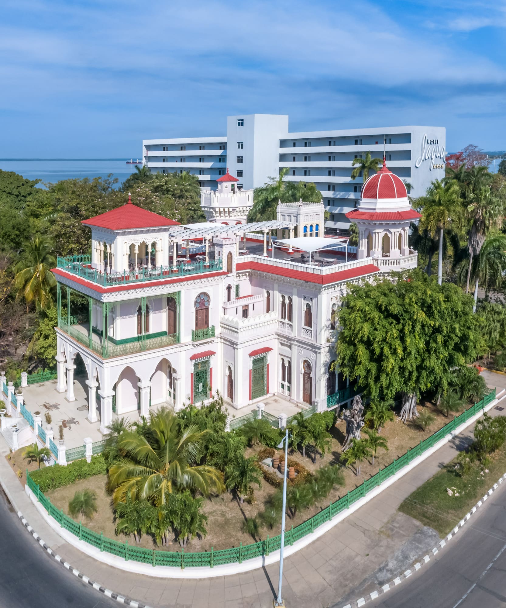 a white building with trees and a road