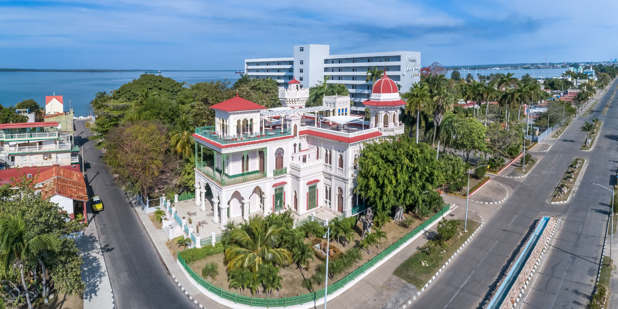 a white building with trees and a road