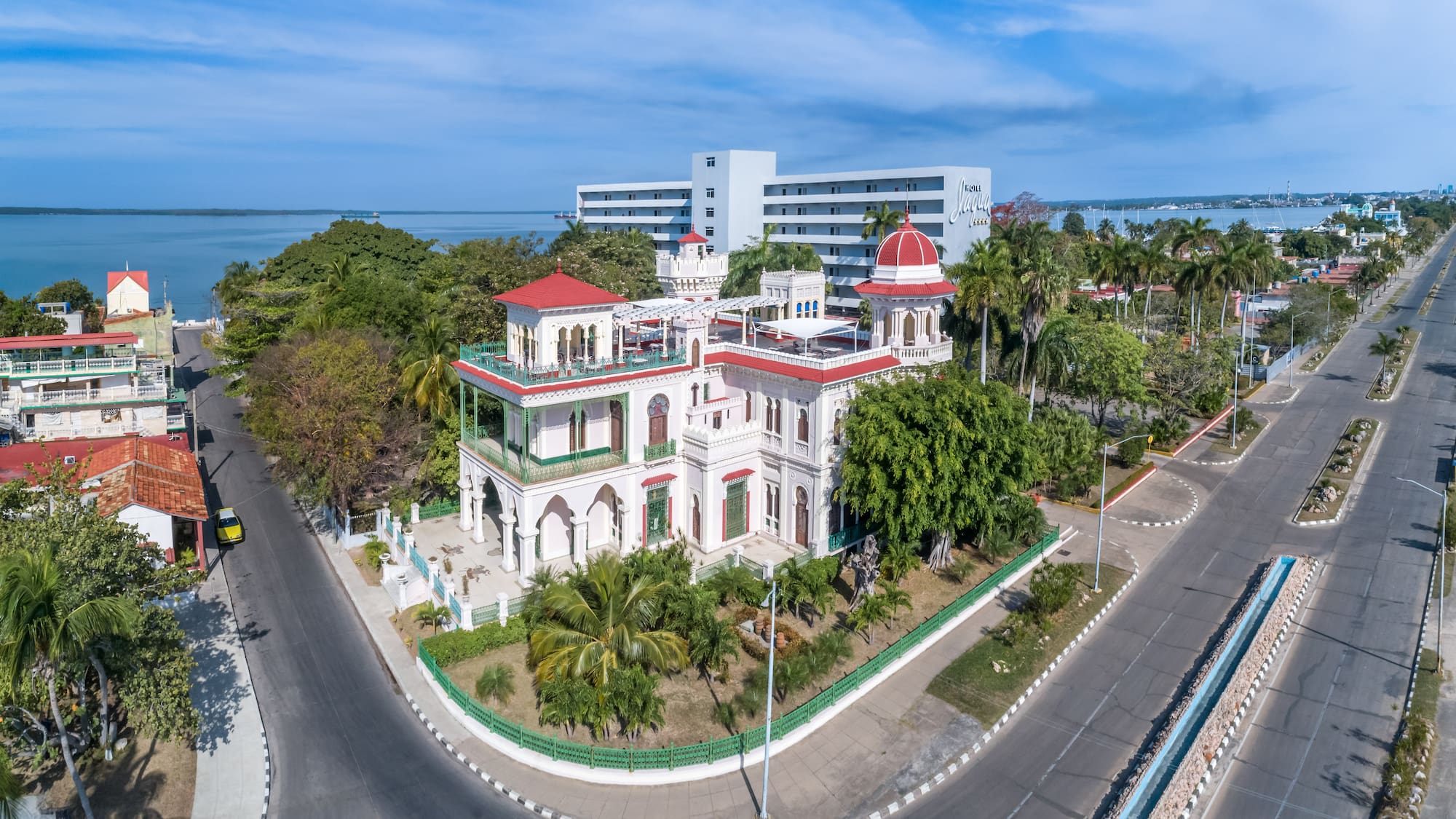 a white building with trees and a road