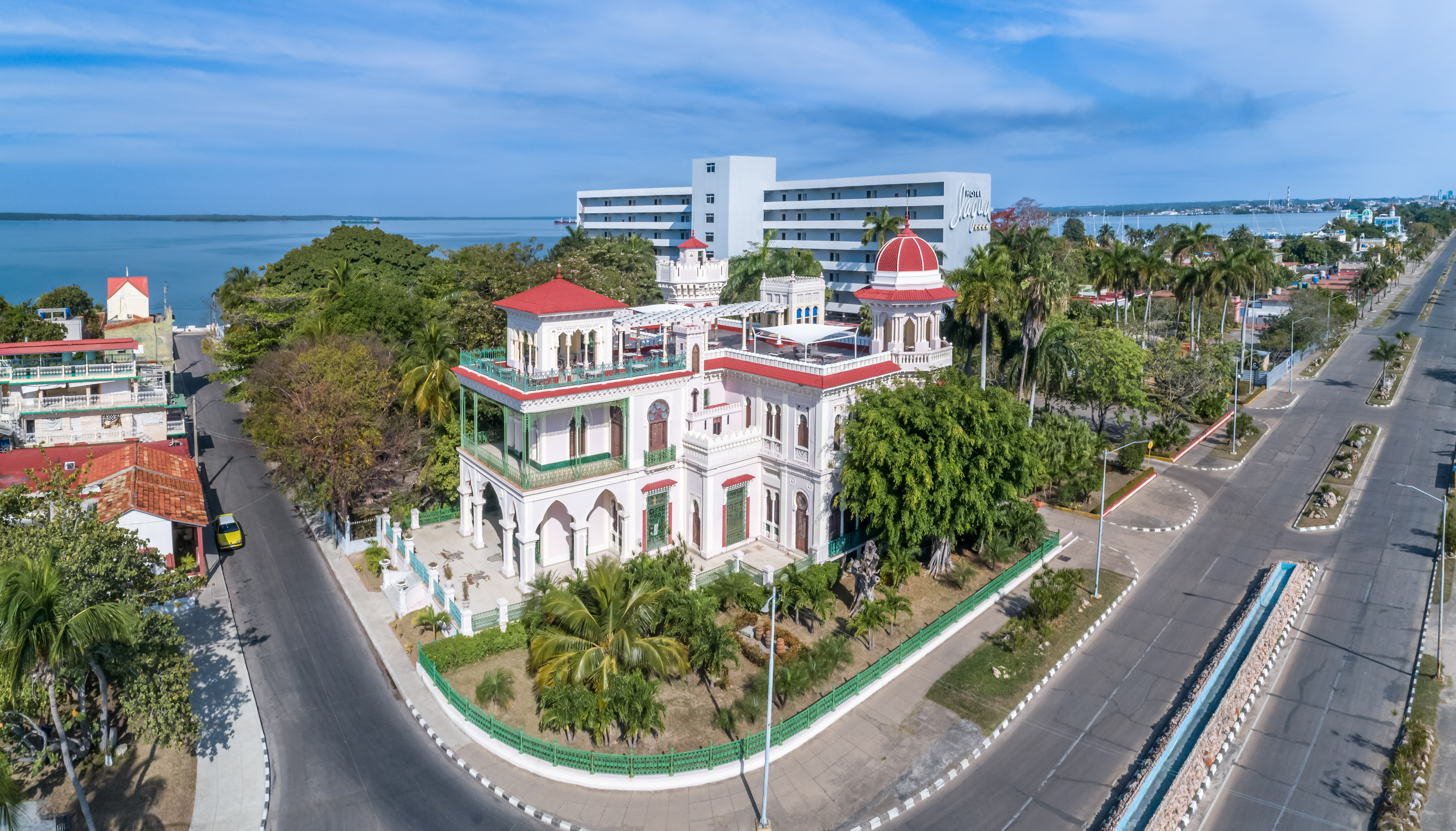 a white building with trees and a road