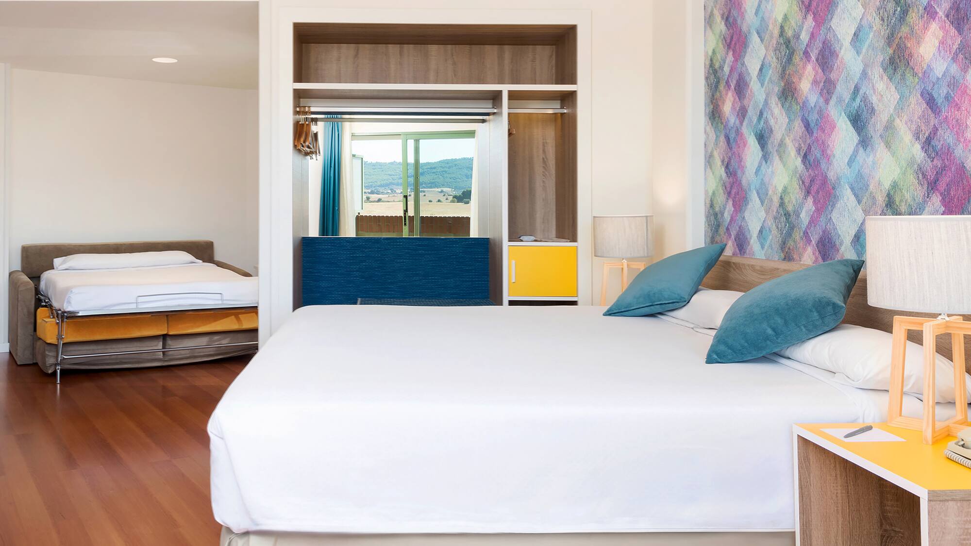 a room with a bed and two beds