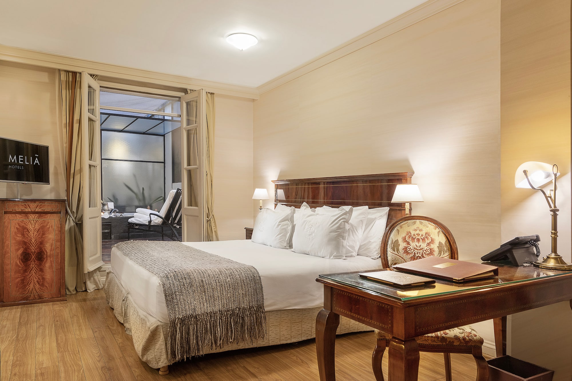 a bedroom with a desk and a bed