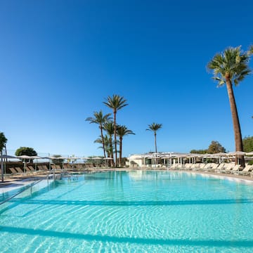 a pool with lounge chairs and palm trees