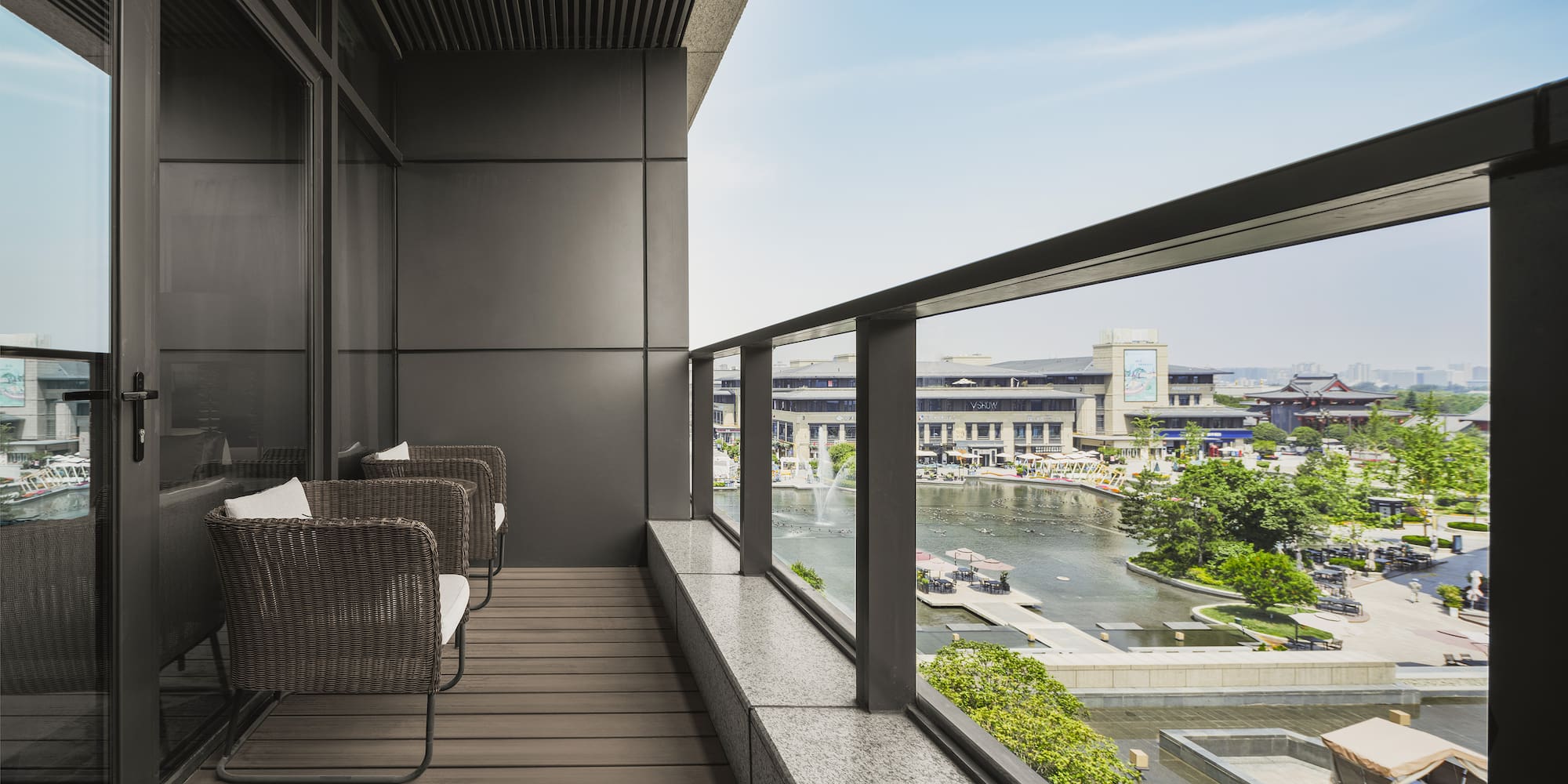 a balcony with chairs and a view of a river and city