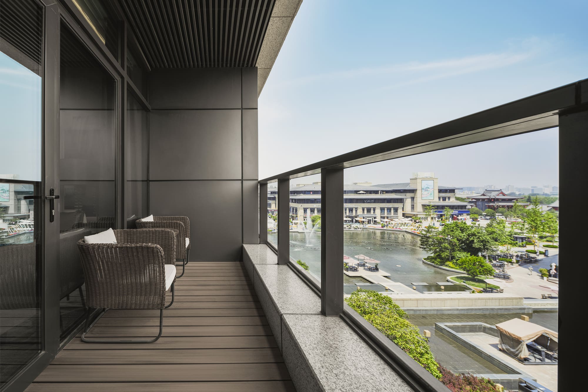 a balcony with chairs and a view of a river and city