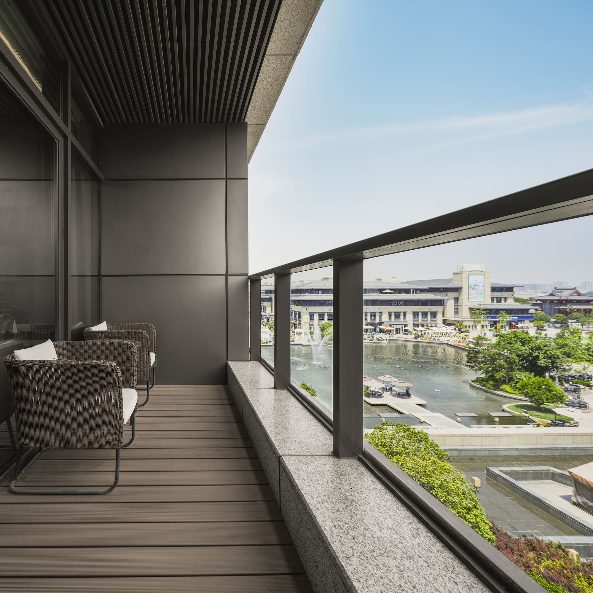 a balcony with chairs and a view of a river and city