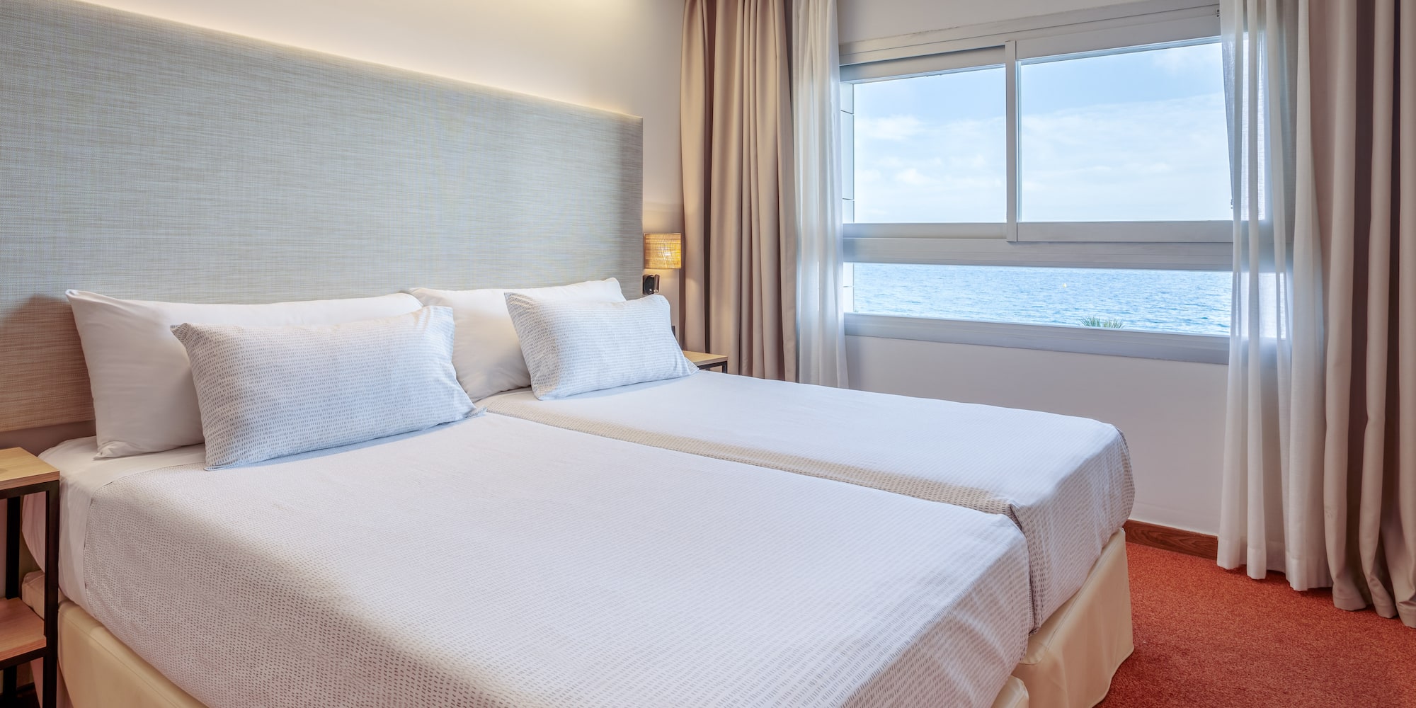 a room with two beds and a window