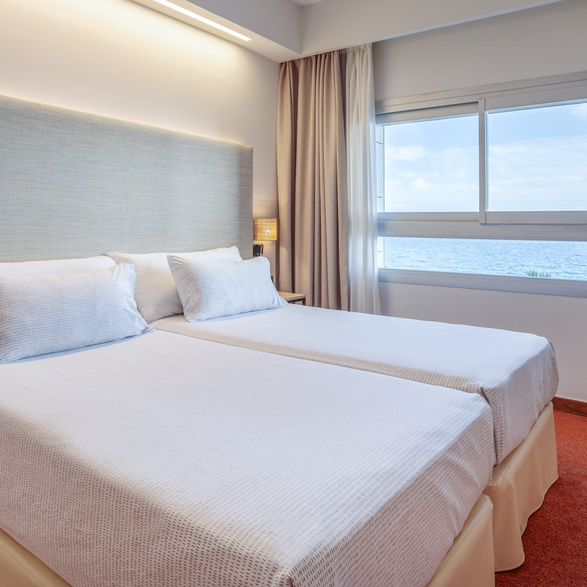 a room with two beds and a window