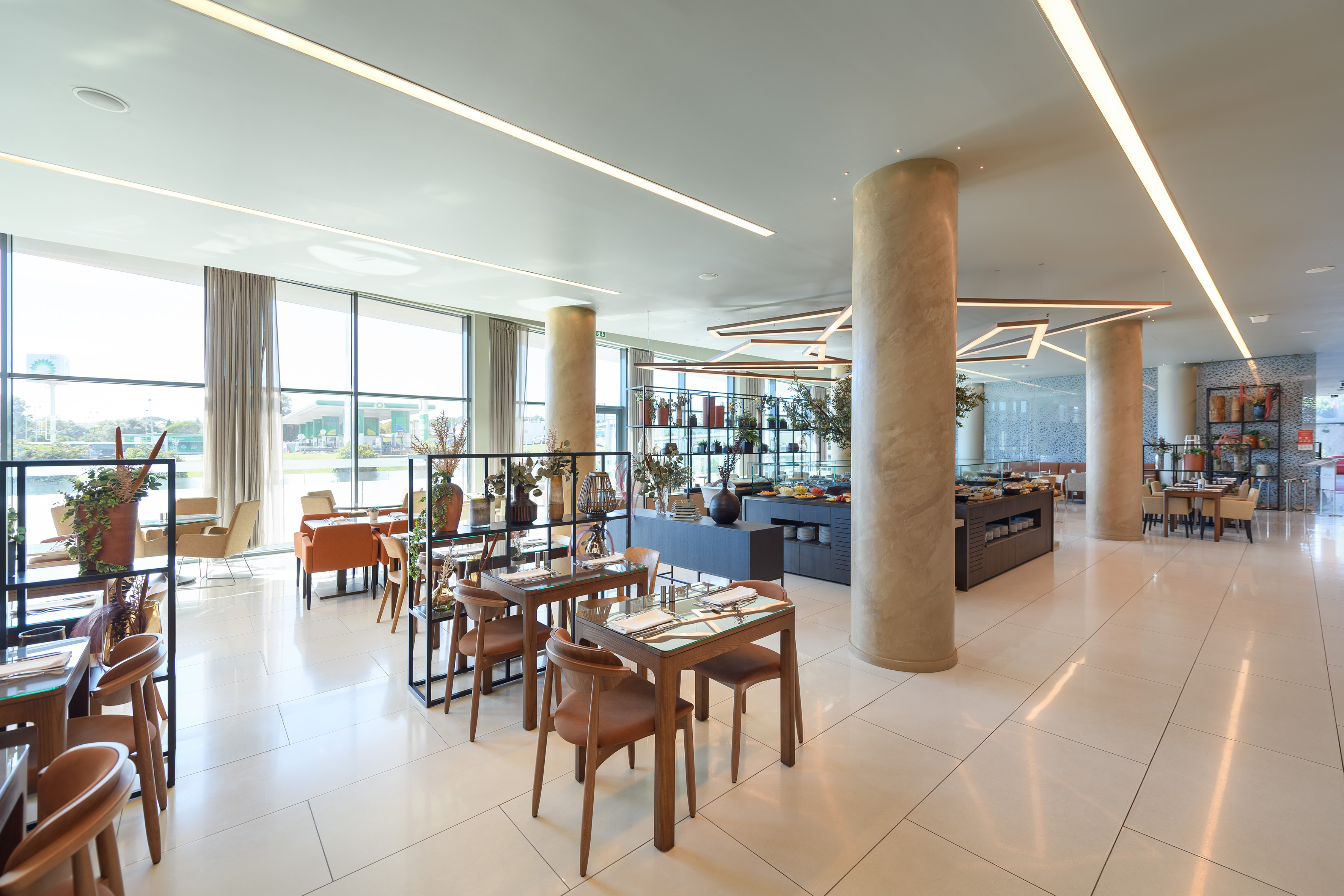 Modern restaurant interior with buffet, dining tables, and large windows.