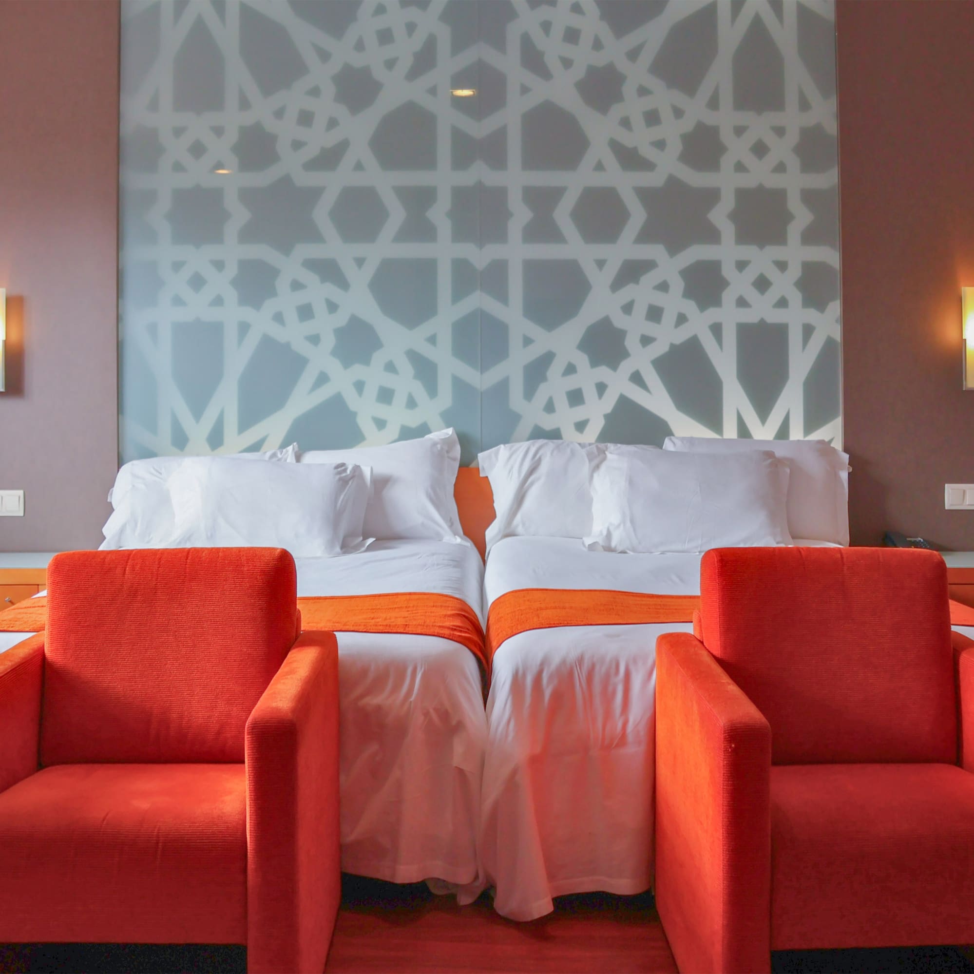 a room with two beds and chairs