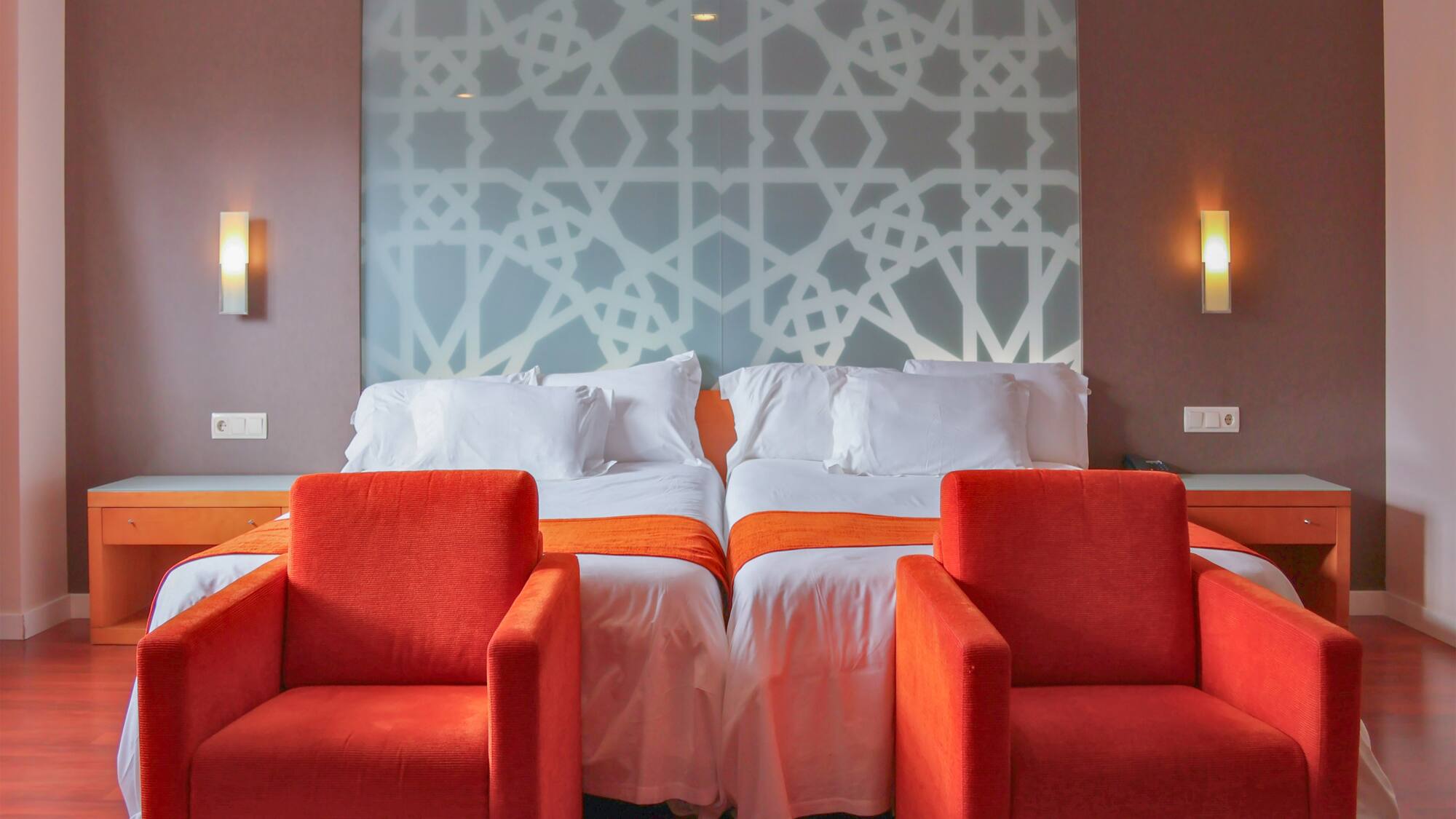 a room with two beds and chairs