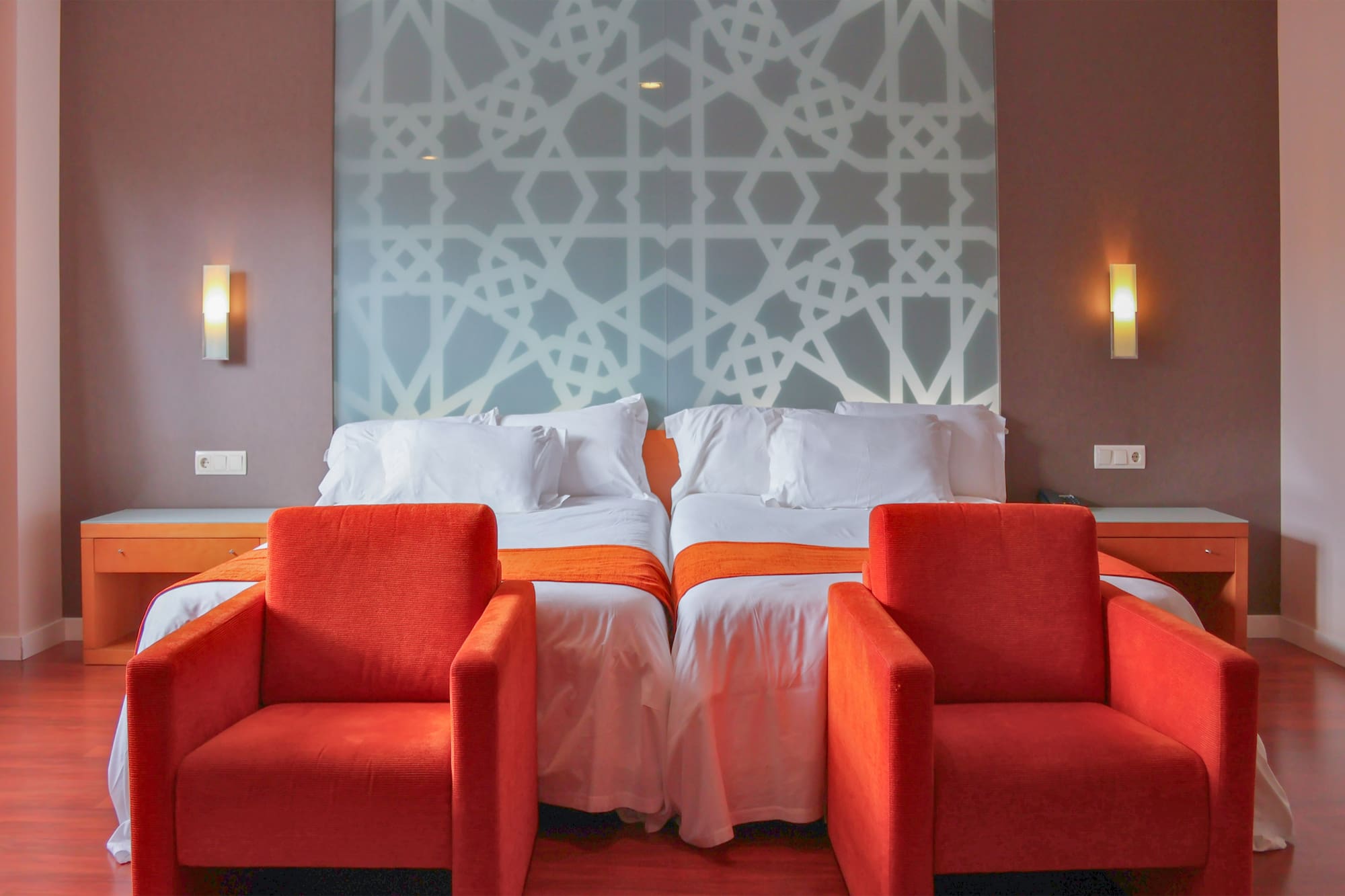 a room with two beds and chairs