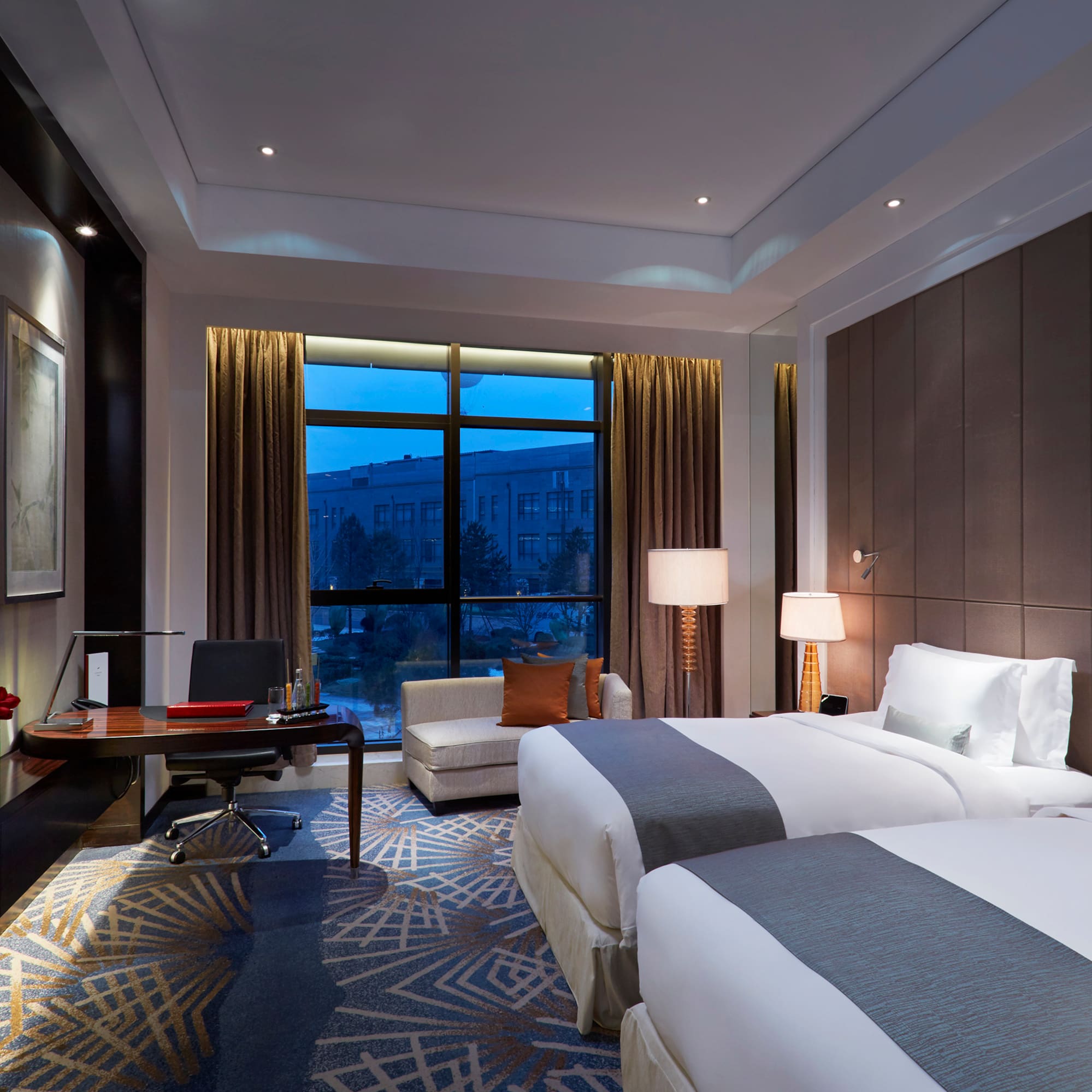 a room with two beds and a desk