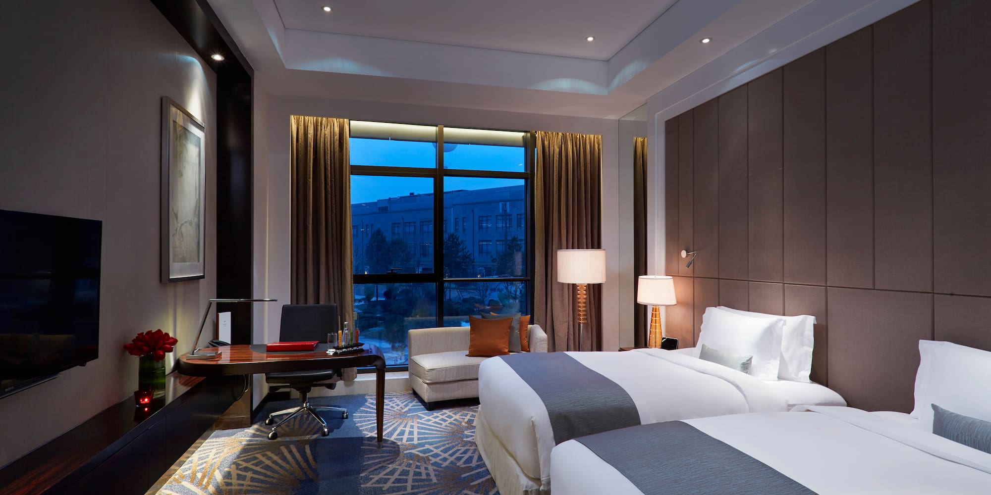 a room with two beds and a desk