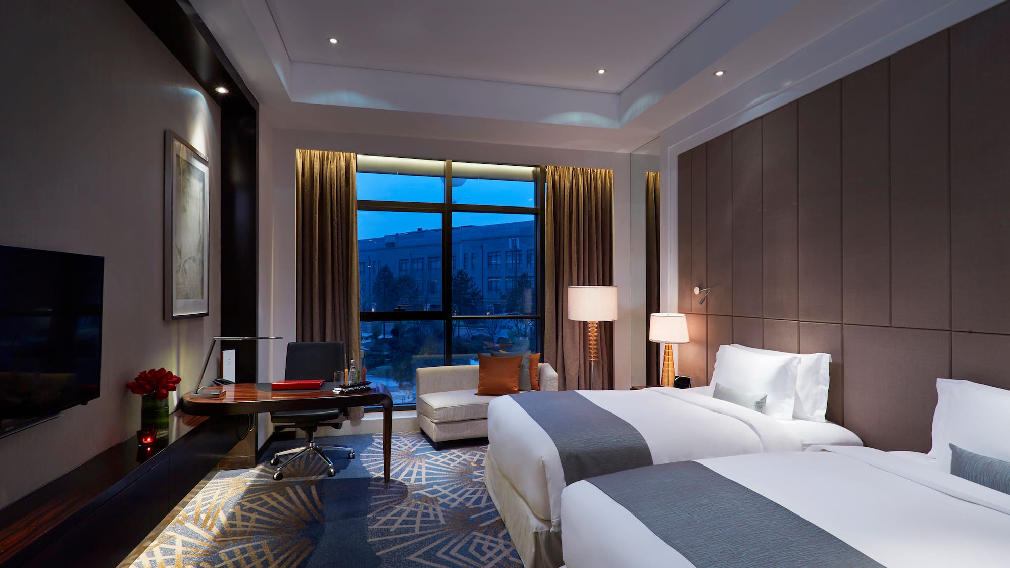 a room with two beds and a desk