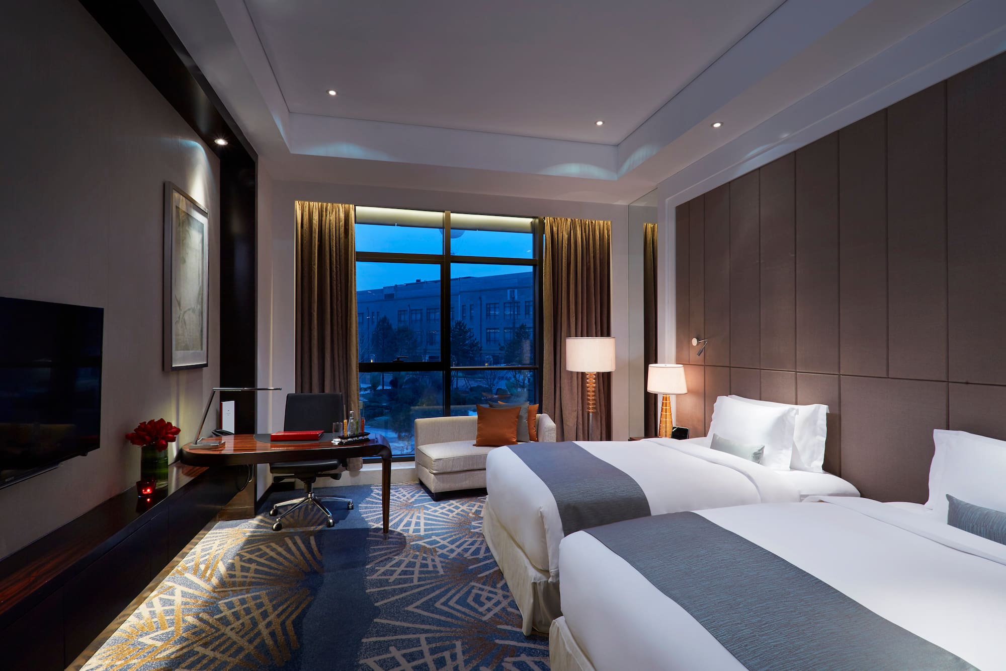 a room with two beds and a desk