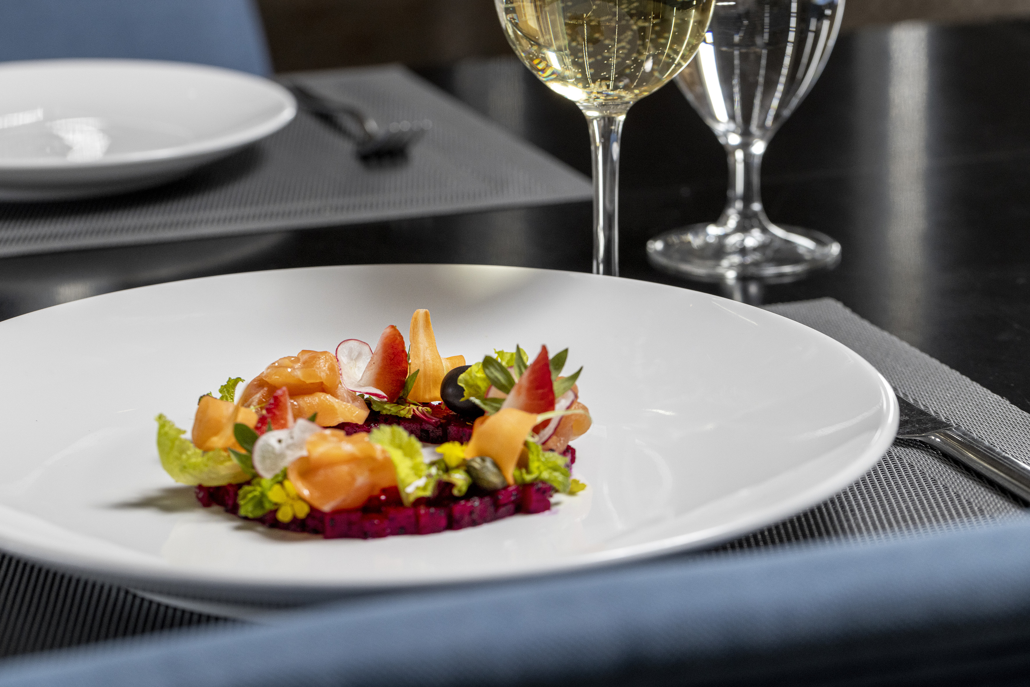 Plated salmon and beetroot salad with fresh fruit and sparkling wine.