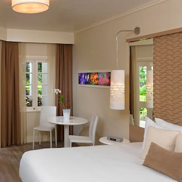 a room with a bed and chairs