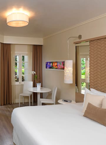 a room with a bed and chairs