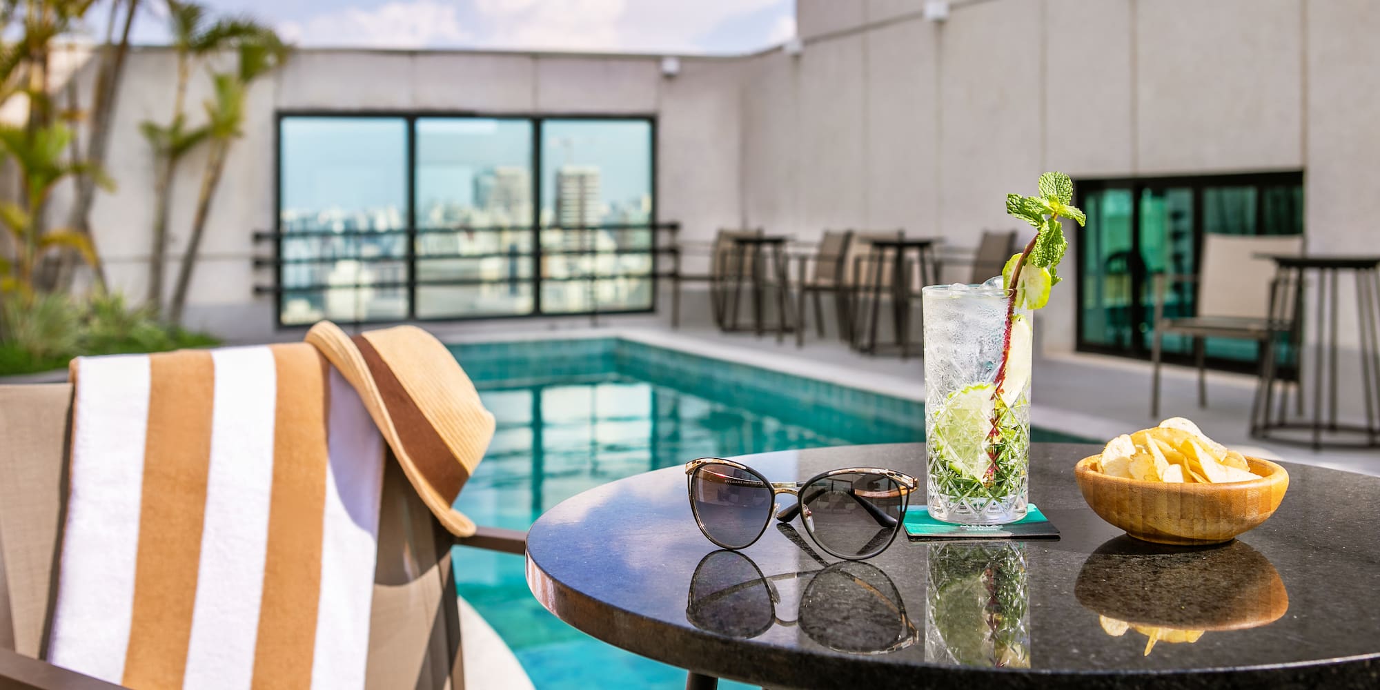 a table with sunglasses and a drink on it