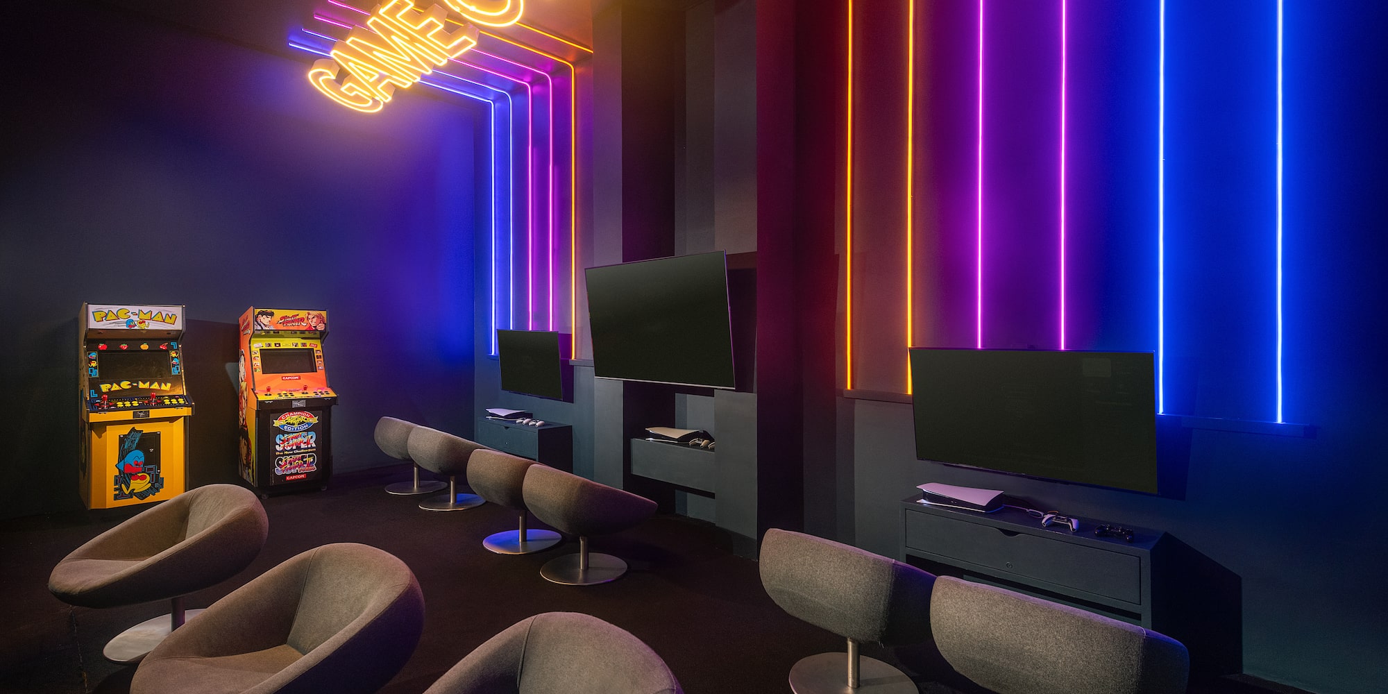 a room with a gaming machine and neon lights