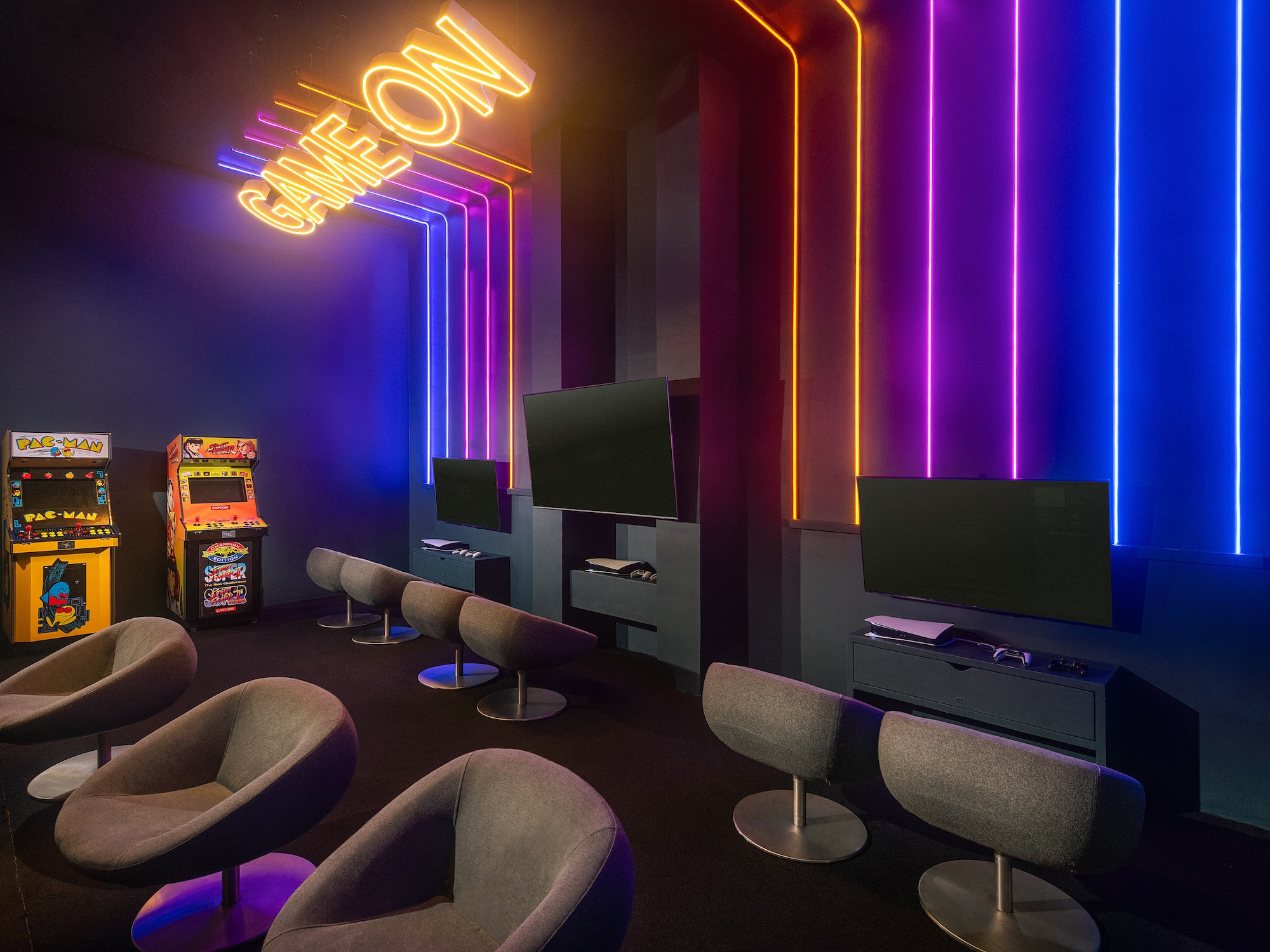 a room with a gaming machine and neon lights