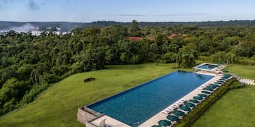 a pool with umbrellas and chairs in a grassy area