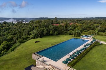 a pool with umbrellas and chairs in a grassy area