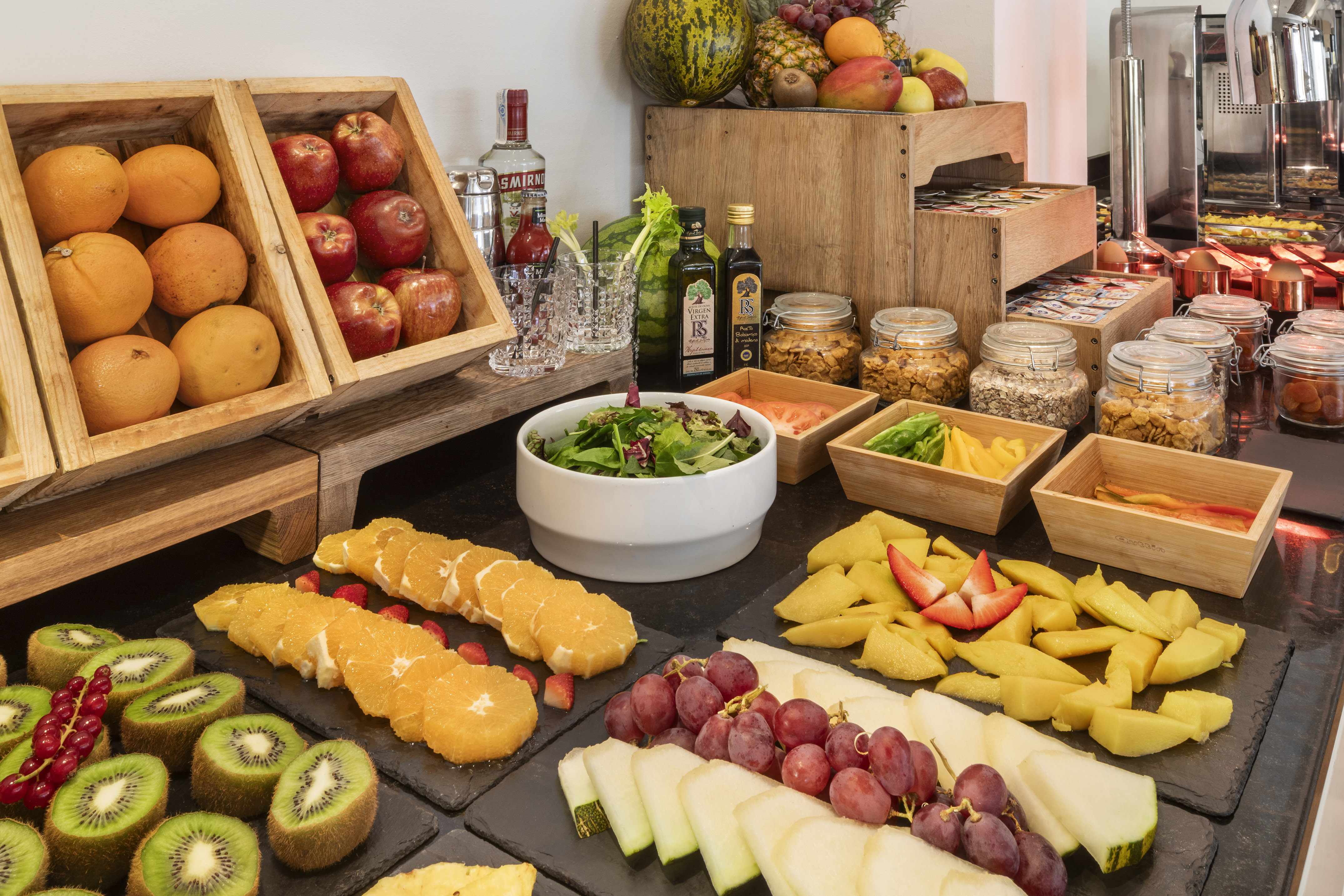 Delicious breakfast buffet spread with fresh fruit, cereals, and salad.