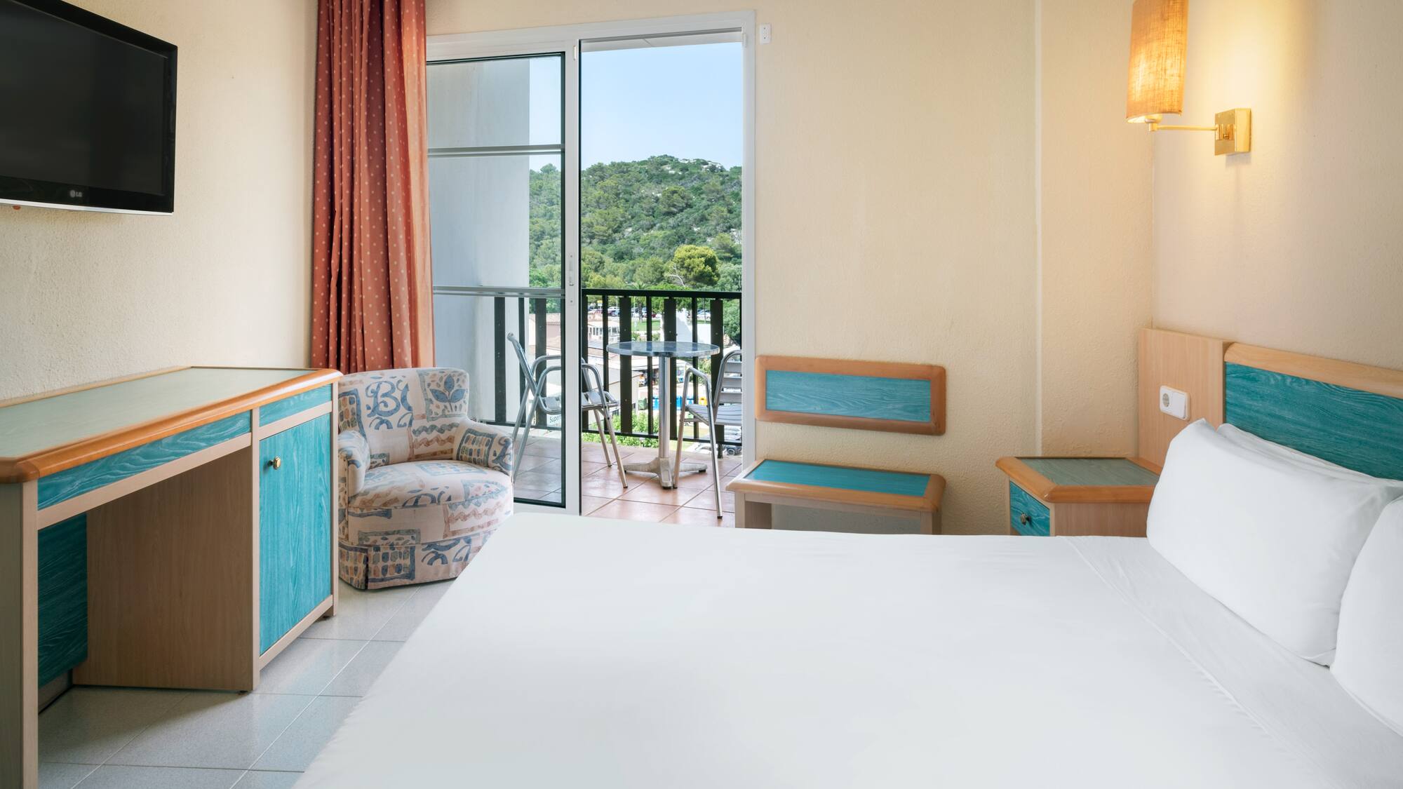 a room with a bed and a chair and a balcony