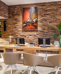 a room with a desk and chairs and a painting on the wall