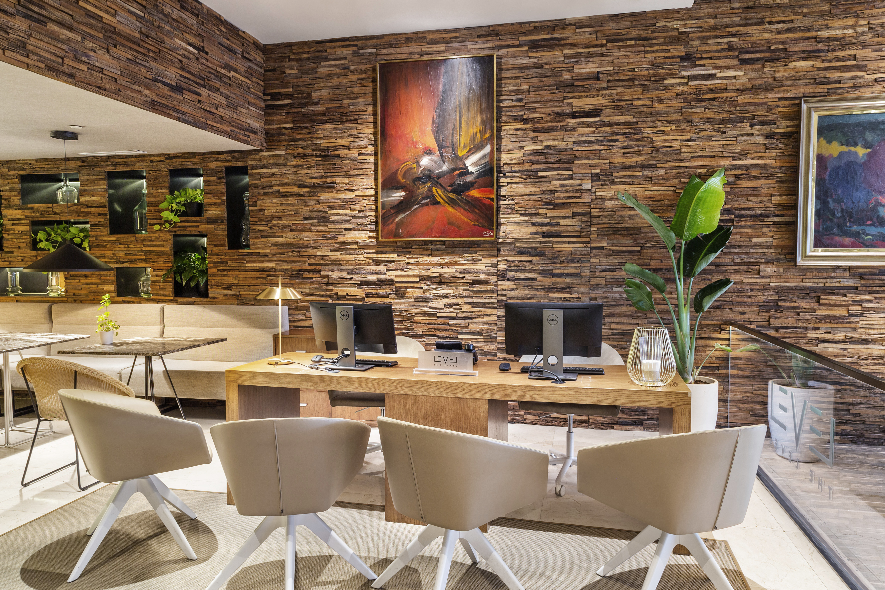 a room with a desk and chairs and a painting on the wall