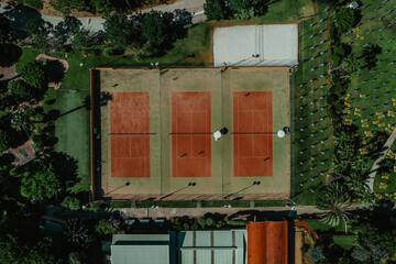 a tennis court with trees and grass