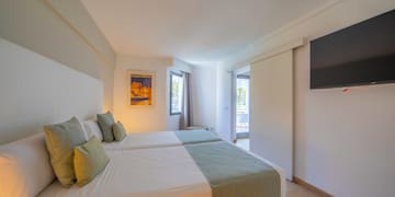 a room with two beds and a television