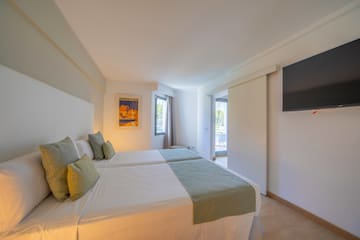 a room with two beds and a television