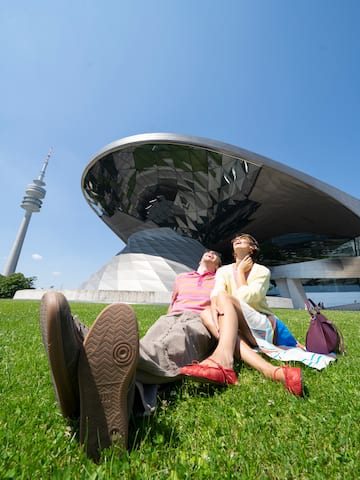 a couple of people sitting on grass in front of a building
