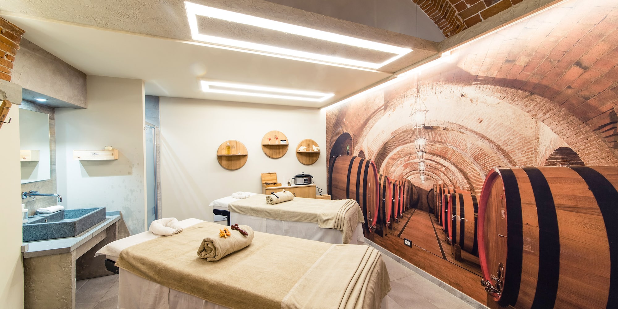 a room with beds and a mural of wine barrels