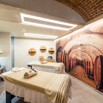 a room with beds and a mural of wine barrels
