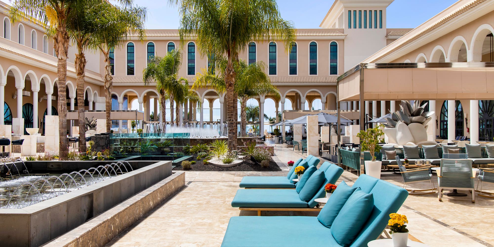 a pool area with chairs and palm trees